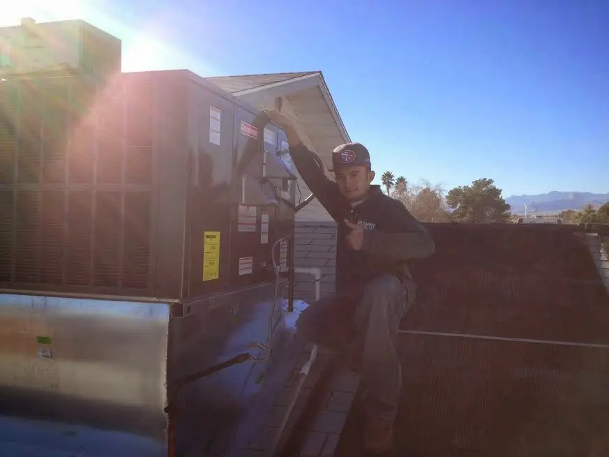 HVAC technician performing AC Tune-Up on a rooftop unit in Carolina Forest